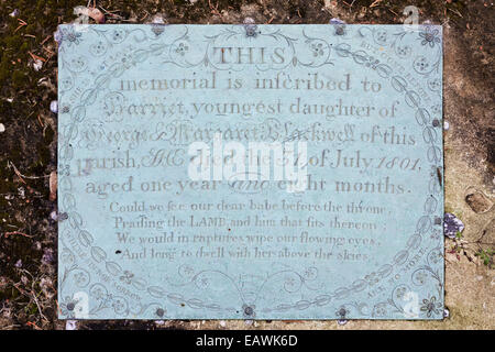 Messingplakette demonstrieren die Kindersterblichkeit auf einem Grabstein in der Cotswold-Dorf Edgeworth, Gloucestershire UK Stockfoto