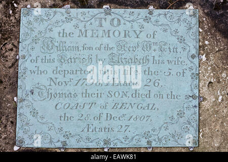 Messingplakette auf einem Grabstein auf dem Friedhof der St. Marys Kirche in der Cotswold-Dorf Edgeworth, Gloucestershire UK Stockfoto