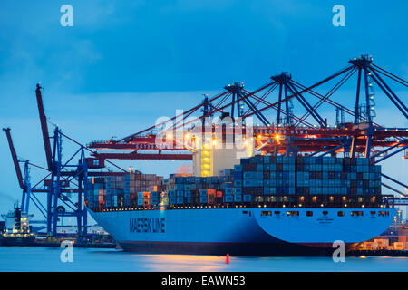 Großes Schiff mit Fracht in einem Hafen in der Abenddämmerung Stockfoto