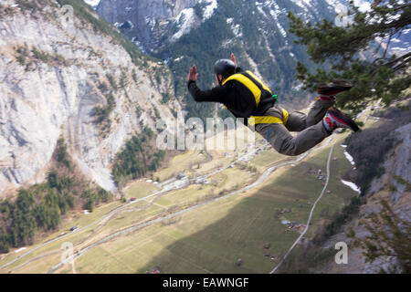 Base-Jumper wird von einer Klippe hinunter in das tiefe Tal beendet. Dabei ist er in einem Wingsuit Tarif Weg von den Felsen zu fliegen. Stockfoto