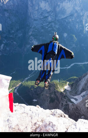 Base-Jumper wird von einer Klippe hinunter in das tiefe Tal beendet. Dabei ist er in einem Wingsuit Tarif Weg von den Felsen zu fliegen. Stockfoto