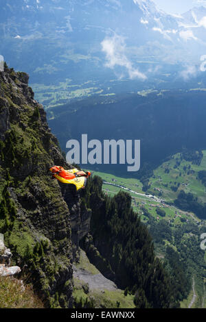 Base-Jumper wird von einer Klippe hinunter in das tiefe Tal beendet. Dabei ist er in einem Wingsuit Tarif Weg von den Felsen zu fliegen. Stockfoto