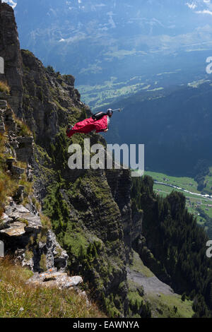 Base-Jumper wird von einer Klippe hinunter in das tiefe Tal beendet. Dabei ist er in einem Wingsuit Tarif Weg von den Felsen zu fliegen. Stockfoto