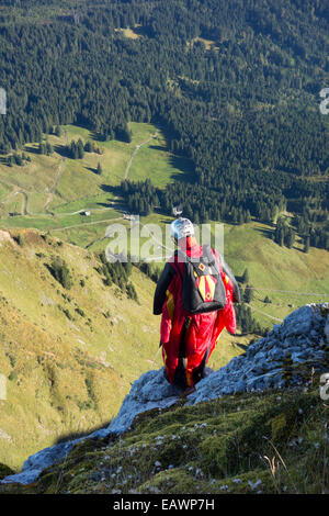 Wingsuit Base-Jumper bereitet sich in das tiefe Tal von einer Klippe springen und er sieht sehr nervös. Stockfoto