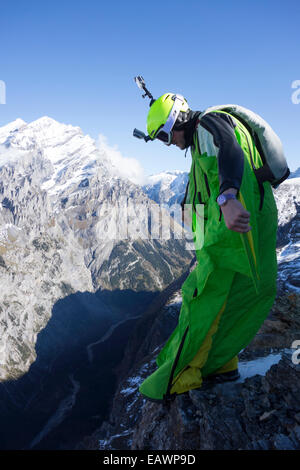 Wingsuit Base-Jumper bereitet sich in das tiefe Tal von einer Klippe springen und er sieht sehr nervös. Stockfoto