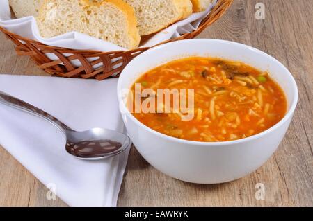 Hausgemachte vegetarische Minestrone-Suppe mit Brot serviert. Stockfoto