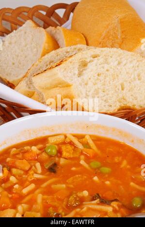 Hausgemachte vegetarische Minestrone-Suppe mit Brot serviert. Stockfoto