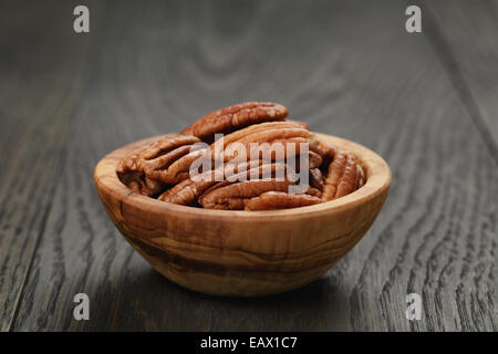 Pekannüsse in Oliven Holz Schüssel auf Eichentisch, rustikalen Stil Stockfoto