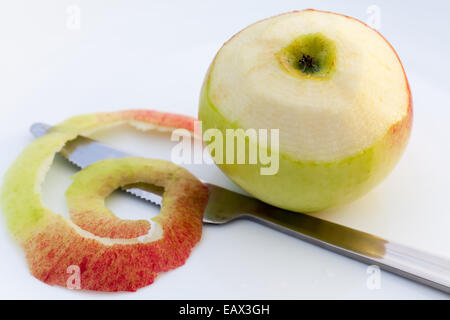 Saftiger Apfel geschält teilweise mit einem Messer. Stockfoto