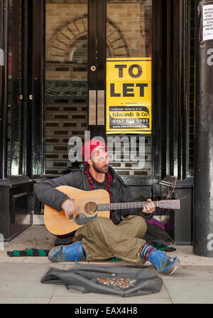 Busker im Shop Eingang mit Gitarrenkoffer, Spenden zu sammeln Stockfoto