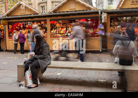 Menschen sitzen & ruht auf Weihnachtsmärkten in St Annes Street, Manchester, UK Stockfoto