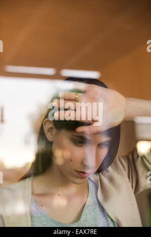 Frau Fenster blickte gelehnt Stockfoto