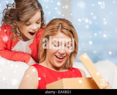 Lächelnde Mutter und Tochter mit Geschenk-Box zu Hause Stockfoto