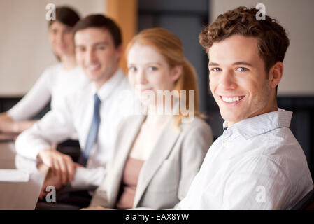 Junge Geschäftsleute sitzen im Konferenzraum Stockfoto