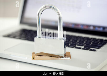 Vorhängeschloss und Kreditkarte sitting on Top of Laptop-computer Stockfoto