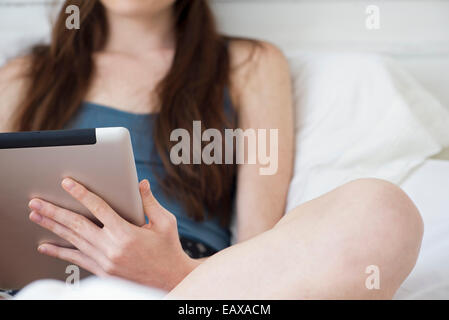 Frau mit digital-Tablette im Bett Stockfoto