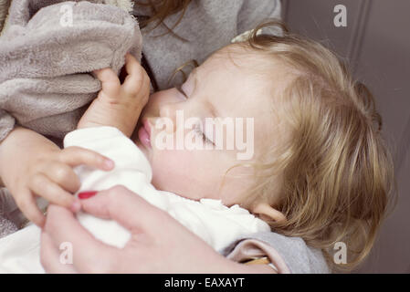 Babymädchen schlafen in den Armen Mutter, beschnitten Stockfoto