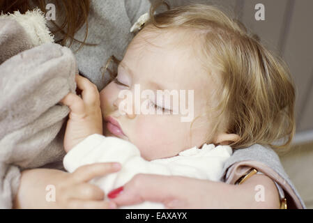 Babymädchen schlafen in den Armen Mutter, beschnitten Stockfoto
