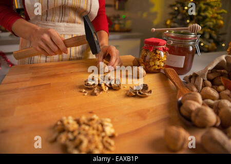 Closeup auf junge Hausfrau hacken Walnüsse in Weihnachten eingerichtet Küche Stockfoto