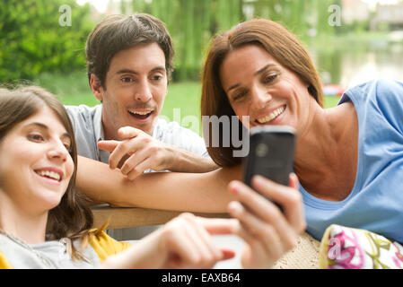 Junge Frau freigeben von Fotos auf Smartphone für Freunde Stockfoto