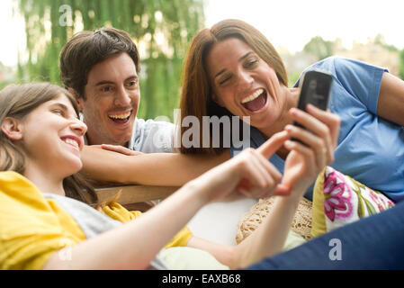 Junge Frau freigeben von Fotos auf Smartphone für Freunde Stockfoto