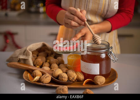 Closeup auf junge Hausfrau Honig Dipper in Honig Glas setzen Stockfoto