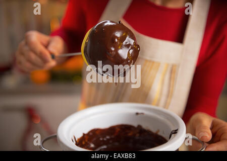 Closeup auf junge Hausfrau macht Apple in Schokoladenglasur Stockfoto