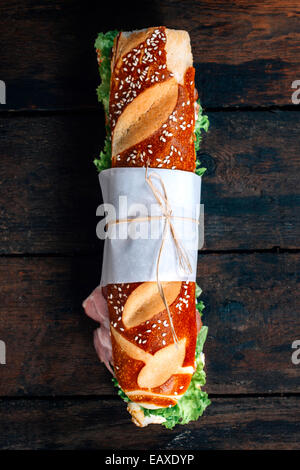 Große u-Boot-Sandwich mit Schinken und Gemüse auf hölzernen Hintergrund von oben Stockfoto