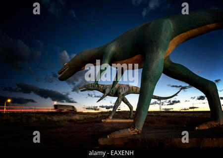 Konkrete Dinosaurier an der alten Route 66 bei Sonnenuntergang, während LKW Streifen von auf i-40. Stockfoto