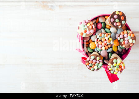 Eis mit bunten Bonbons von oben auf weißem Holz Hintergrund mit Leerzeichen, selektiven Fokus Stockfoto