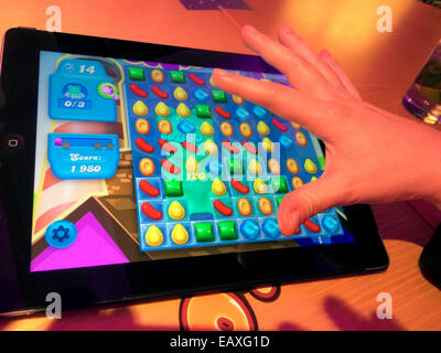 Eine Frau spielt das Spiel Candy Crush Soda Saga auf dem iPad in London, Großbritannien, 20. November 2014. Foto: Teresa Dapp/dpa Stockfoto