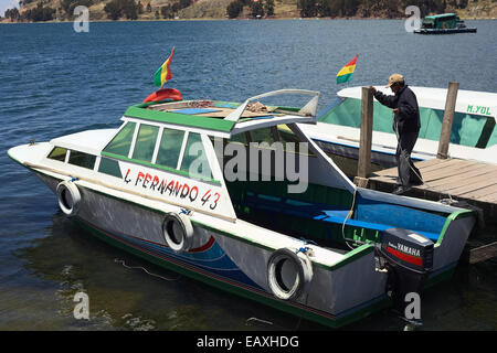 Mann auf Anlegestelle in ein Motorboot am Ufer des Titicaca in San Pablo de Tiquina in Bolivien Stockfoto