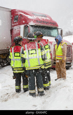 Vail, Colorado - Ersthelfer diskutieren, wie man einen querstehenden LKW blockiert die westwärts Gassen der Interstate 70 zu entfernen. Stockfoto