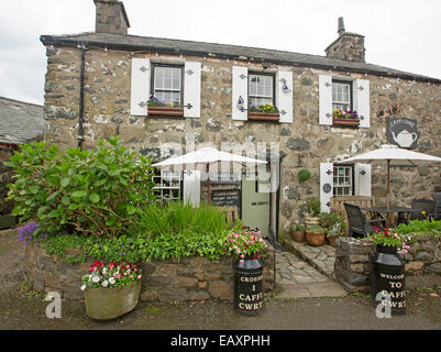 Attraktive Teestube im alten Landhaus aus Stein mit Sitzmöglichkeit im Freien in bunten Garten & Zeichen in Walisisch in Criccieth Wales Stockfoto