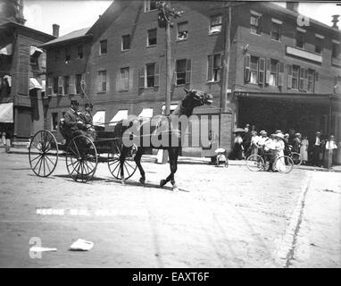 Dieses historische Foto aus dem Jahr 1911 zeigt Feuerwehrmänner, die an der Parade am 4. Juli in Keene, New Hampshire, teilnehmen. Die Feuerwehrleute marschieren stolz mit ihrer Ausrüstung und feiern den Nationalfeiertag. Dieses Bild zeigt die amerikanische Tradition der Gemeindeparaden im frühen 20. Jahrhundert und die Rolle der Feuerwehr bei lokalen Festlichkeiten. Stockfoto