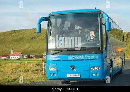 Im Reisebus-Fahrer und Guide mit Reisegruppe fahren auf einer Straße in der Nähe von einem ländlichen Bauernhof-Bereich auf der Ringstraße, Island Stockfoto