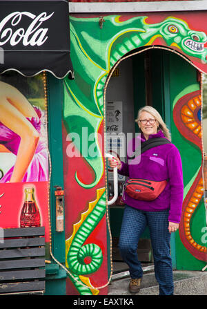 Bunt gekleidete Frau verlassen Drenkin Grill auf Laugavegur Straße in der Innenstadt von Reykjavik, Island Stockfoto