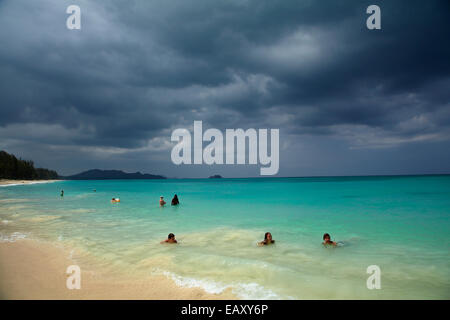 Menschen schwimmen in Waimanalo Beach und Gewitterwolken, Oahu, Hawaii, USA Stockfoto