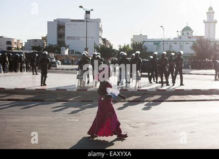 Dakar, Senegal. 21. November 2014. Ein Anhänger des ehemaligen Präsidenten Senegals Abdoulaye Wade verläuft von der Polizei während einer Demonstration in der Stadt Zentrum von Dakar, Senegal, 21. November 2014. Unter der Leitung von Senegalais demokratische Partei (PDS), Senegals Oppositionsparteien eine groß angelegte Demonstration gegen den amtierenden Präsidenten Macky Sall und seine Regierung hier am Freitag, acht Tage vor dem 15. Sommet der internationalen Unternehmen der Frankophonie in Dakar am 29. November und 30 stattfindenden. Bildnachweis: Li Jing/Xinhua/Alamy Live-Nachrichten Stockfoto