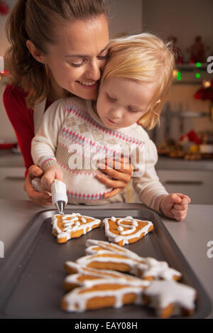 Porträt der glückliche Mutter und Baby machen Weihnachtsplätzchen in Küche Stockfoto