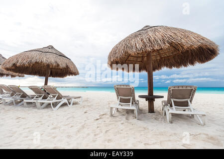 Sonnenschirme und Liegestühle am Karibik-Strand, Cancun, Mexiko Stockfoto