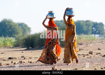 Frauen schleppen einen Wasserkrug auf dem Kopf, um Wasser aus einer natürlichen Quelle zu holen Stockfoto