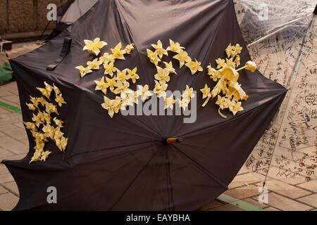 Schwarzen Regenschirm mit gelbem Papierblumen geschmückt und Sonnenschirme in Admiralty, Hong Kong Stockfoto