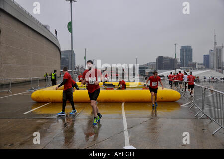 London, UK, Samstag, 22. November 2014. Tausende von Läufern, Suche nach Schlamm und Hindernisse, Abstieg auf Wembley-Stadion, in das große Finale 2014 Herren Gesundheit Survival Of The Fittest Serie teilzunehmen.  Survival Of The Fittest London bringt das große Arena-Gefühl zu diesem klassischen urbanen Hindernislauf. Historisch findet am Battersea Power Station, umgezogen Survival Of The Fittest Standorte in diesem Jahr zum Wembley-Stadion. Erwärmt, beginnen alle 15 Minuten lassen Sie Hunderte von eifrigen Läufer durch ein speziell dafür gebauten 10 k-Hindernis-Parcours rund um dieses legendären Londoner Veranstaltungsort.   Vorjahressieger dou Stockfoto