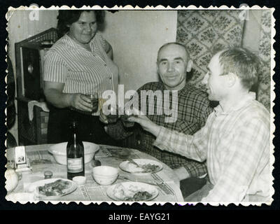 UdSSR - CIRCA 1970: Ein antikes Foto zeigt Frau und zwei Männer trinken Wodka Stockfoto