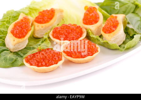 Roter Kaviar in Gebäck und Salat auf Teller. Stockfoto