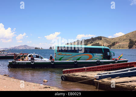 Motorisierte Holzfähre geladen mit Bus und Auto in San Pablo de Tiquina am Ufer des Titicaca in Bolivien Stockfoto