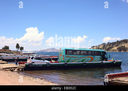 Motorisierte Holzfähre geladen mit Bus und Auto in San Pablo de Tiquina am Ufer des Titicaca in Bolivien Stockfoto