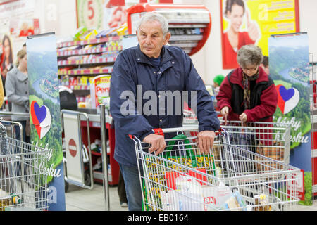 Leute einkaufen Supermarkt Wagen älterer Mann Schieben Trolley Senior Shopper Schieben Warenkorb innerhalb der Mall Kunden Rentner Senior Erwachsene Retiree Stockfoto