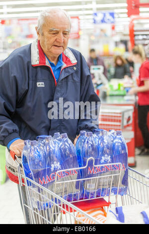 Erwachsener Seniorenmann schiebt Trolley-Shopping im Supermarkt, Mineralwasser Prag, Tschechische Republik Europa Stockfoto